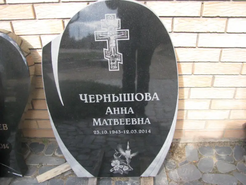 Простой памятник с гравировкой креста и буквами