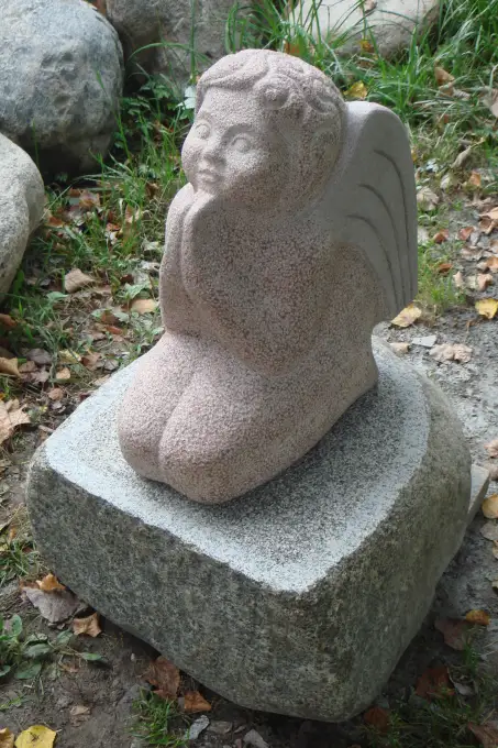 Amors nolaidies uz laukakmens, rakurss, skats no augšas, skulptūras virsma rokas kalums