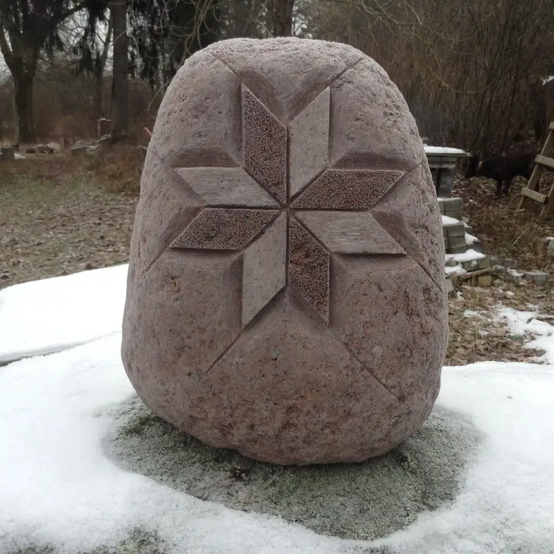 Latvijas karogkrāsas akmenī iekalts Auseklis, mirīgos un tuvos, pasteļtoņos toņos