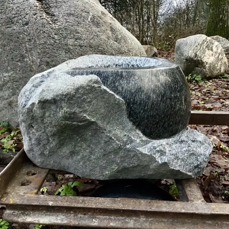 Puķu trauks, kas it kā iznāk ārā no klints. tēlnieks Ronalds Jaunzems