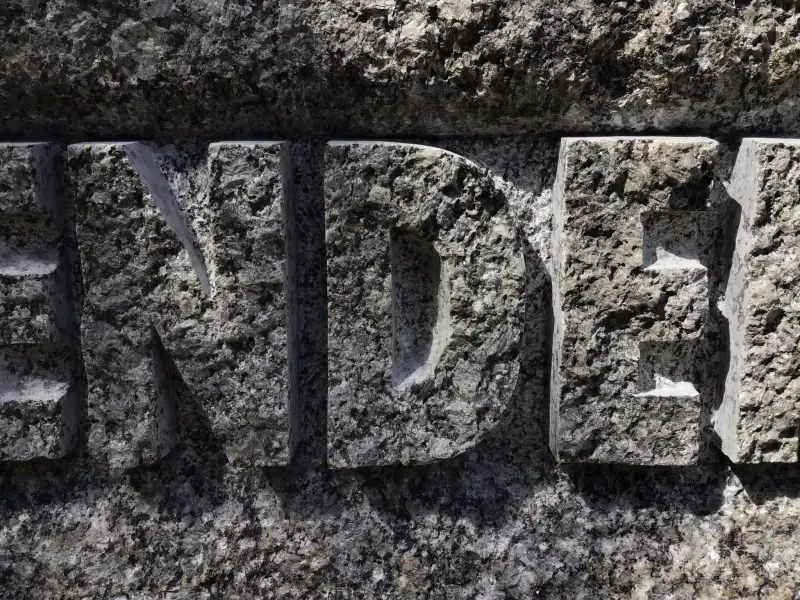 Lielformāta burtu uzraksts - iekalts laukakmenī