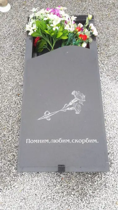 Daļēji slēgts granīta kapu apmale ar gravējumu