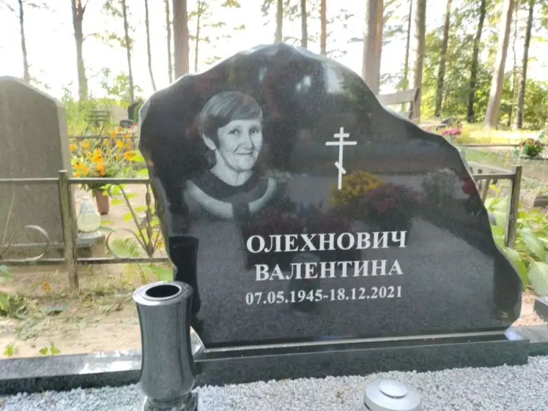 Melna granīta piemineklis ar portreta gravējumu