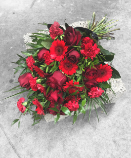 Mourning bouquet with red roses, carnations, gerberas and black ribbon