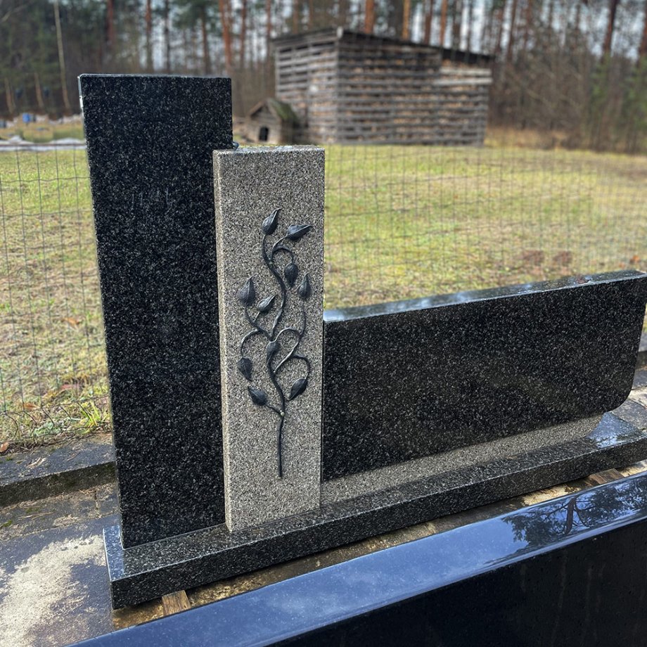 Piemineklis no tumšā un gaišā granīta ar dekoratīvu kalta zaru motīvu
