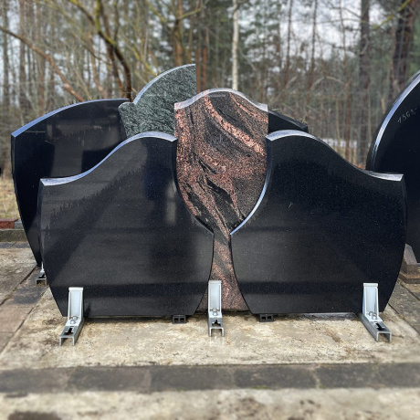 Dubultais kapu piemineklis no divām melna izliektu granīta plāksnēm ar sarkana granīta plāksni centrā