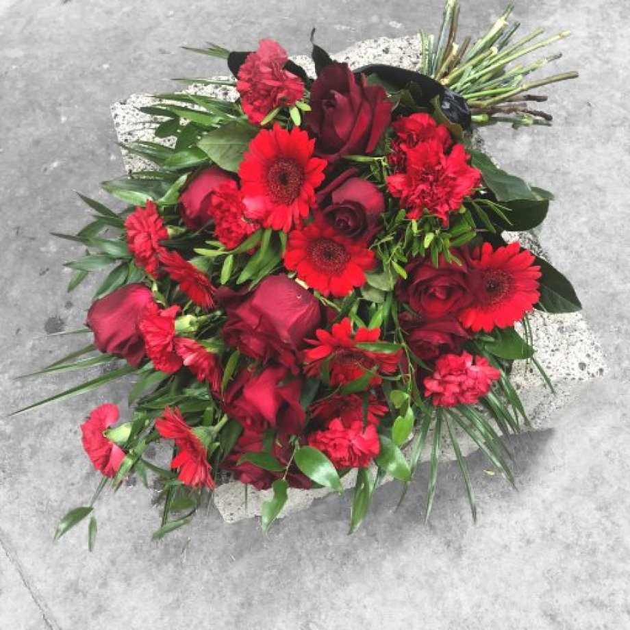 Mourning bouquet with red roses, carnations, gerberas and black ribbon
