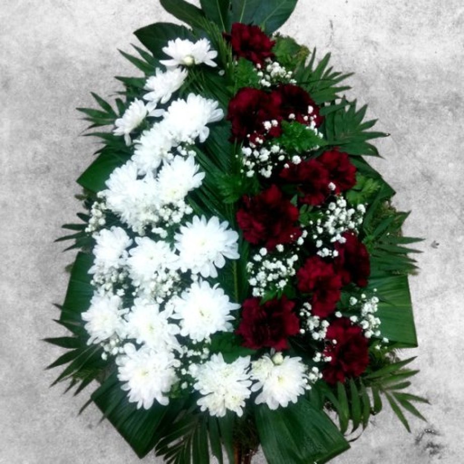 Funeral spray of freshly cut white chrysanthemums and dark red carnation flowers