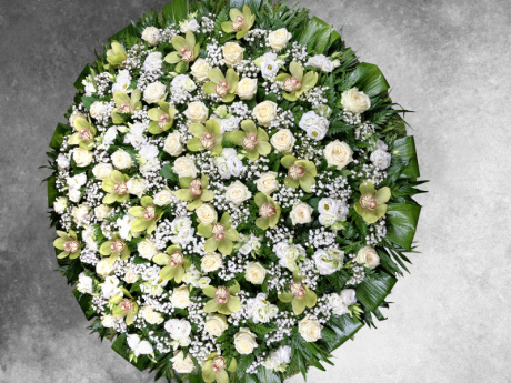 Elegant funeral wreath with white roses and yellow orchid flowers