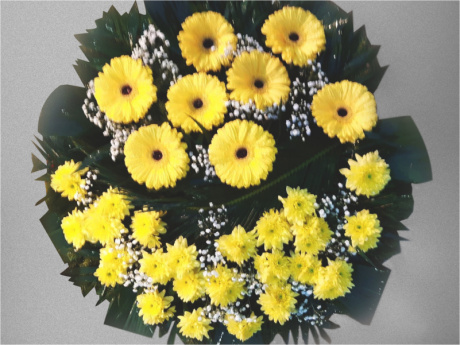 Bright and heartfelt funeral wreath made from freshly cut yellow flowers