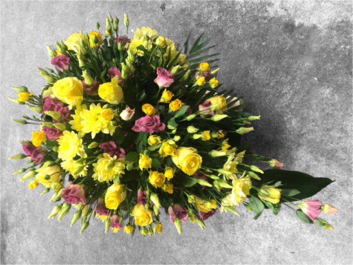 Funeral spray made of yellow and pink flowers