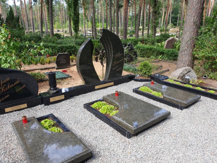 Granite tombstone in an asymmetric shape with a wrought iron element