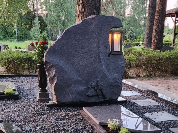 Rough-cut granite headstone with a candle holder