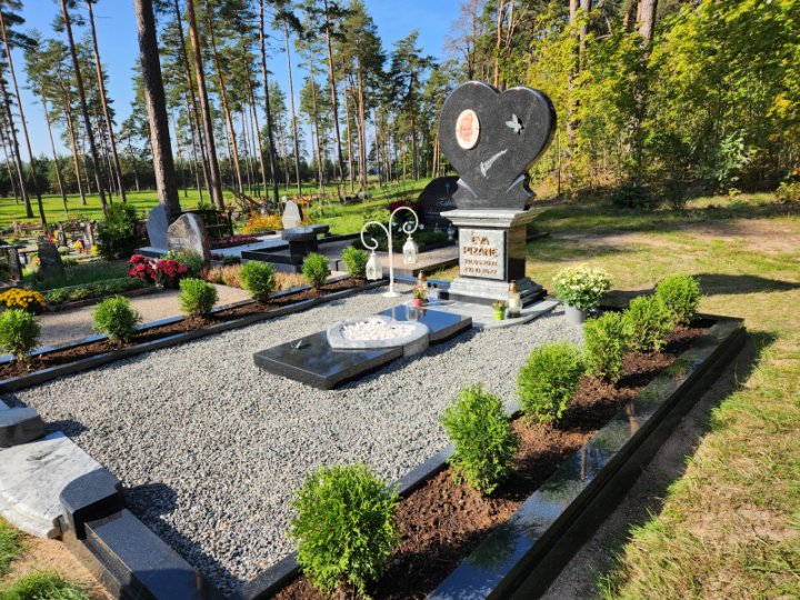 A funerary monument with a heart on an elegant pedestal, made of black and white granite