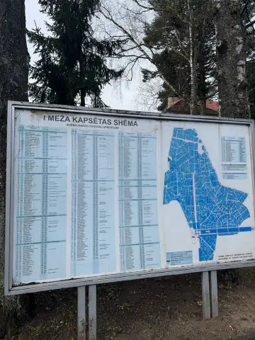 Informatīvais stends ar Meža kapu plānu pie kapsētas ieejas.
